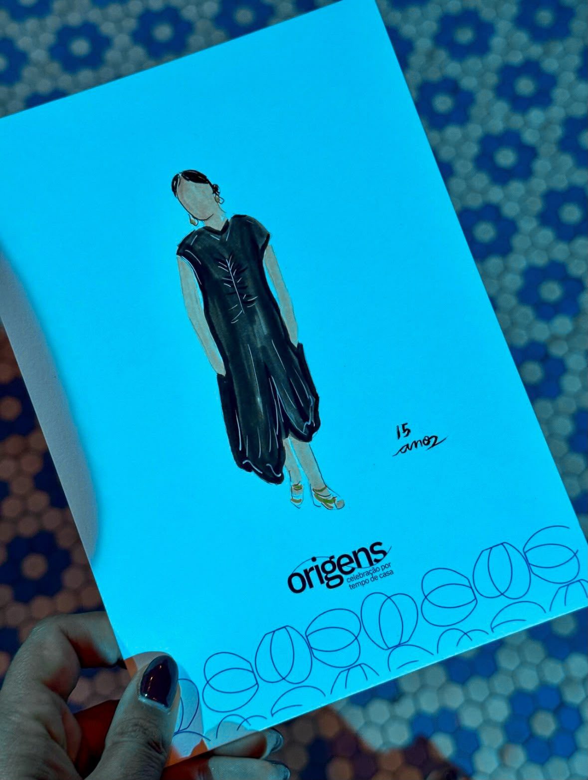 Retrato em aquarela de uma colaboradora de vestido preto, cartão Origens com a inscrição 15 anos · Souluarte