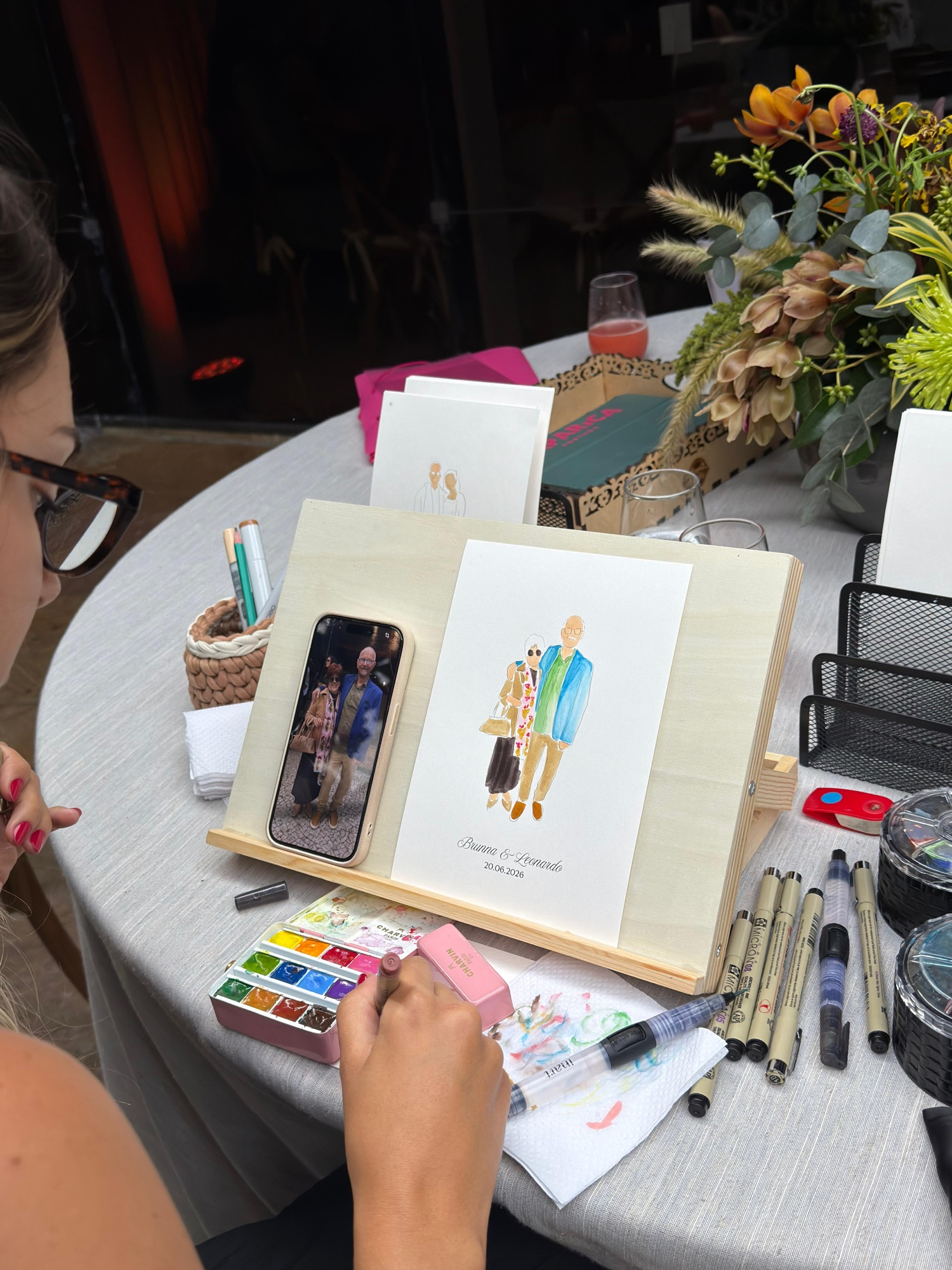 Watercolour portrait of a couple on personalised paper, painted from a photo on the artist's easel · Souluarte