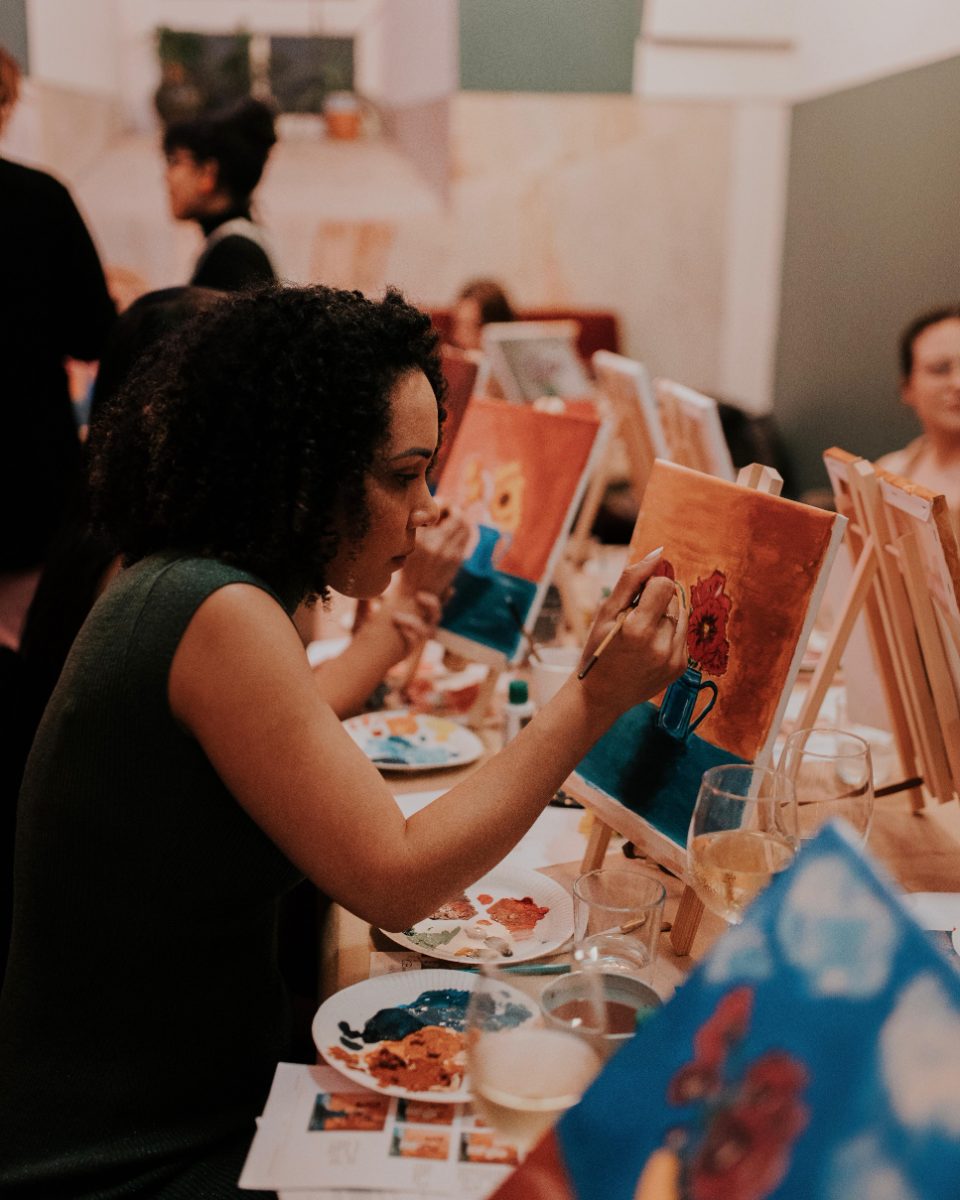 Participant painting a poppy in a blue jug on canvas · Souluarte