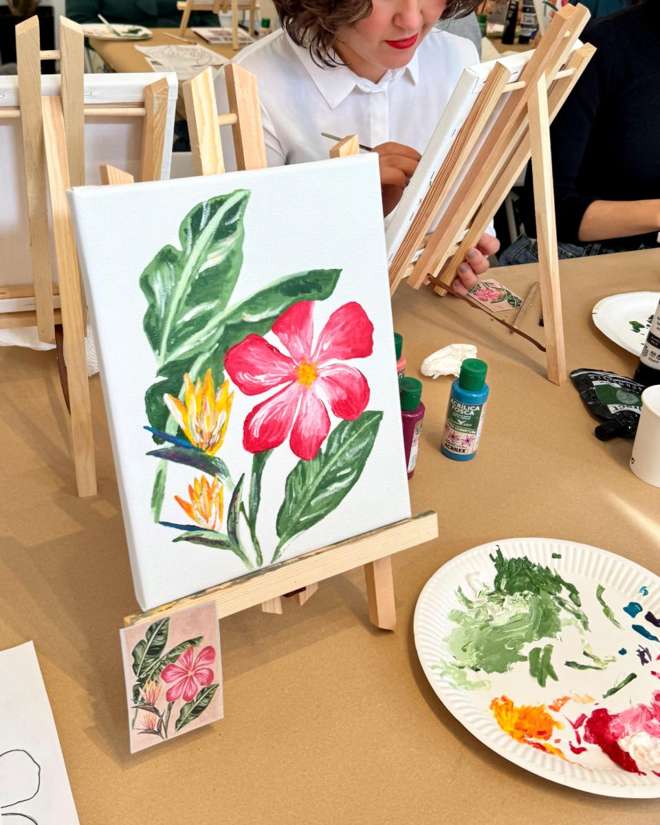 Finished hibiscus canvas on the easel beside the reference card · Souluarte